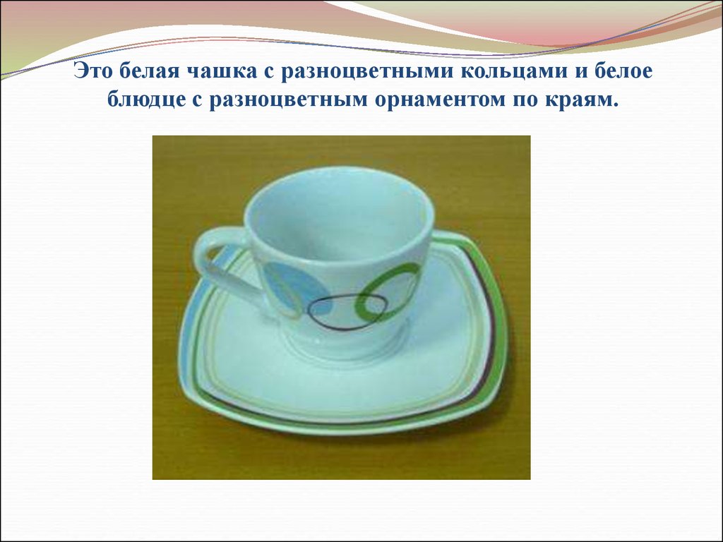 Это белая чашка с разноцветными кольцами и белое блюдце с разноцветным орнаментом по краям.